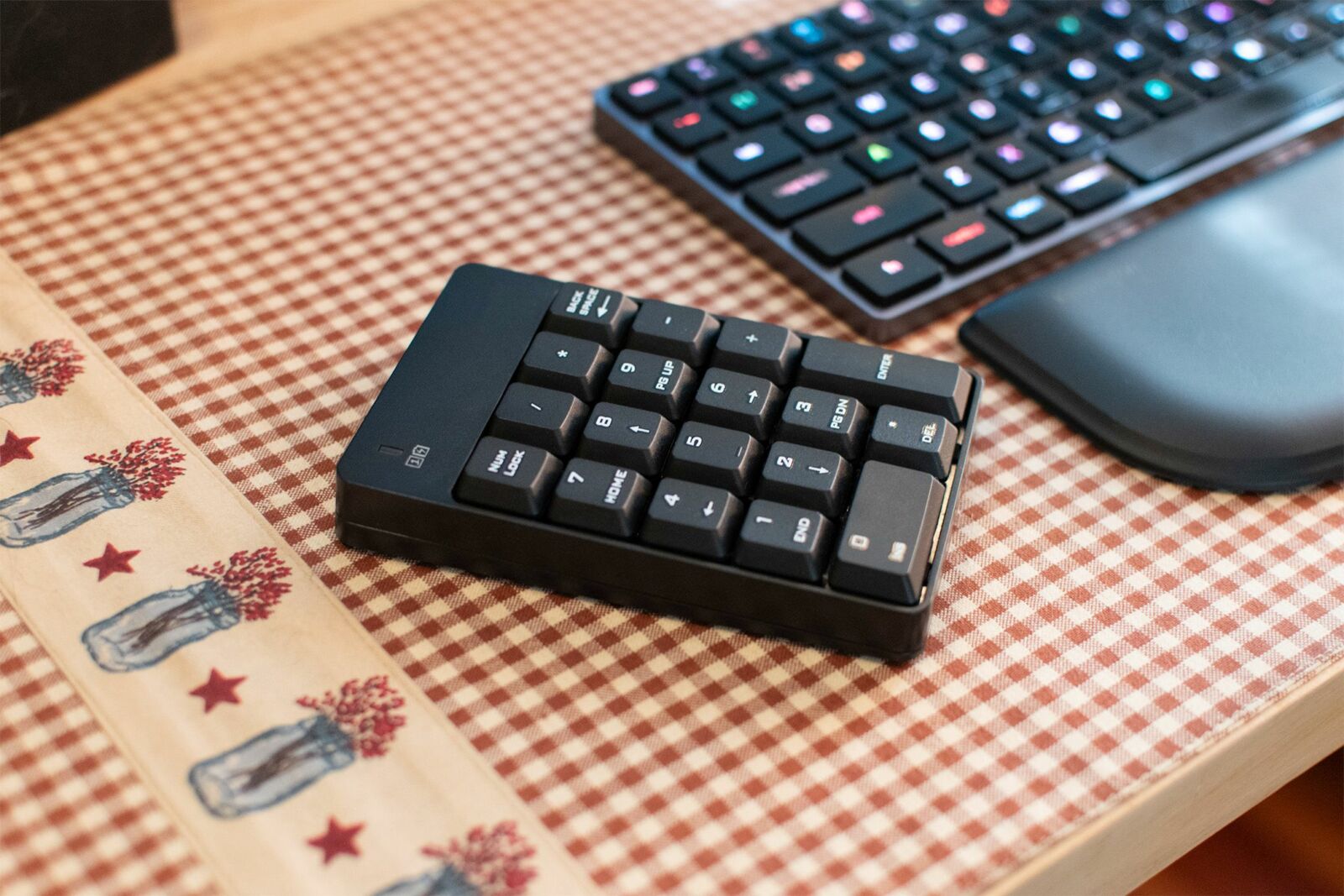 A standalone wireless numpad on the left-hand side of a tenkeyless keyboard.