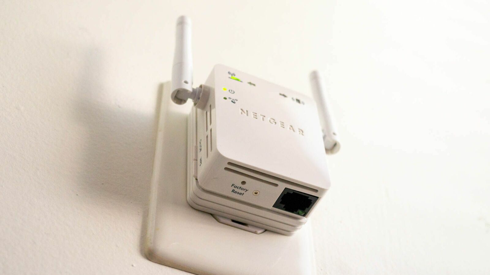 Netgear Wi-Fi extender plugged into an outlet.