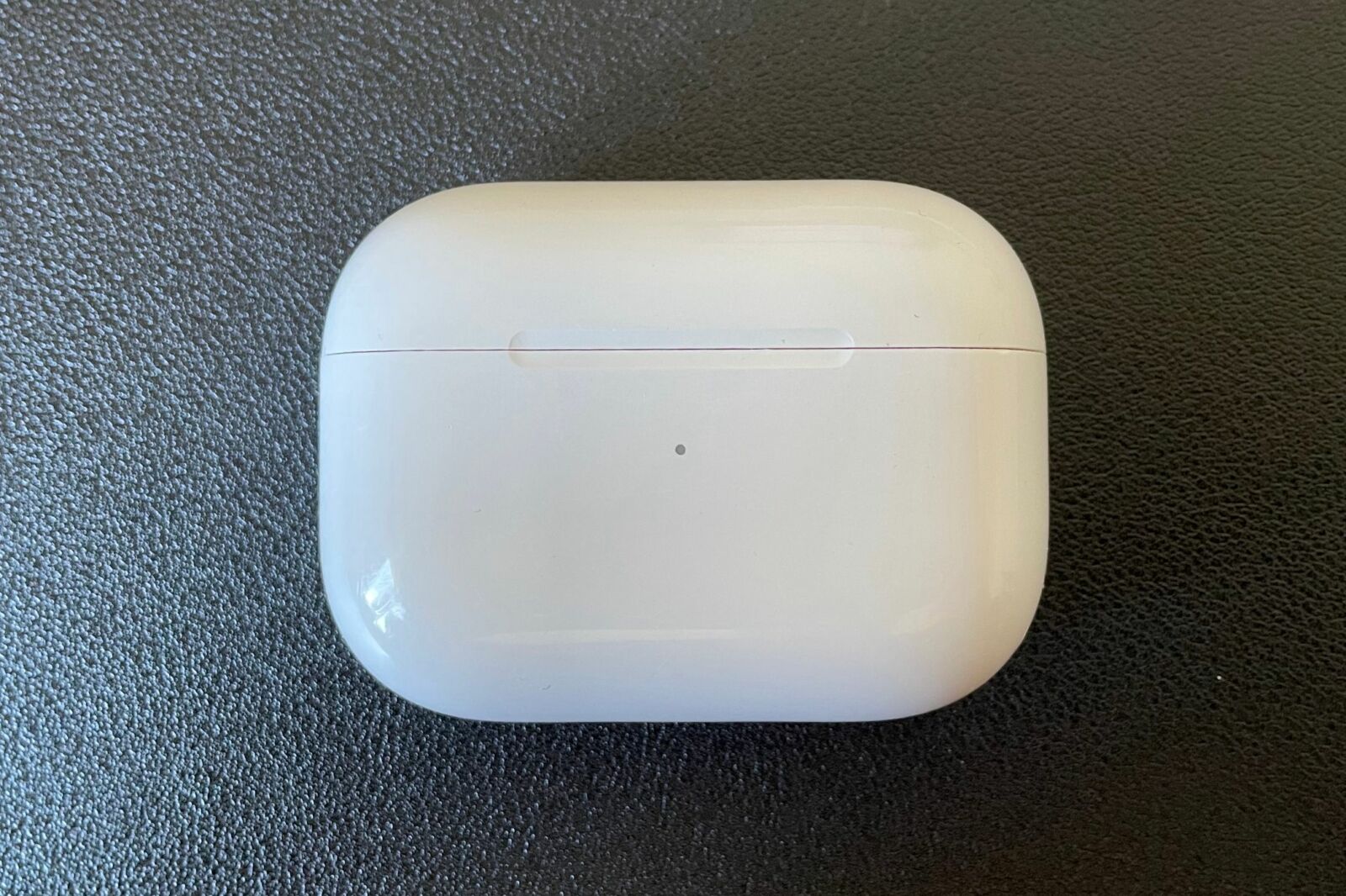 AirPods Pro inside charging case on black background.