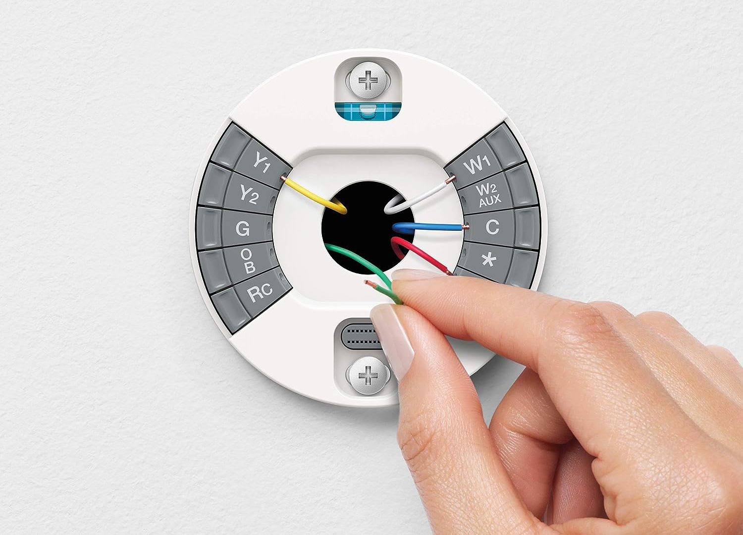 A person installing the backplate on a Google Nest Learning Thermostat.